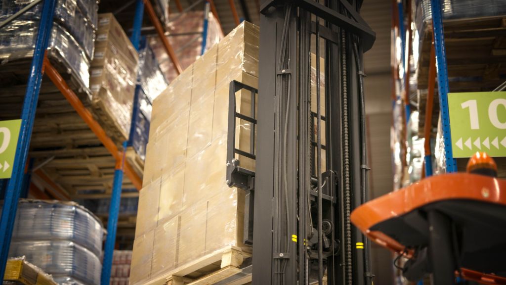 a forklift lifting up a loaded pallet